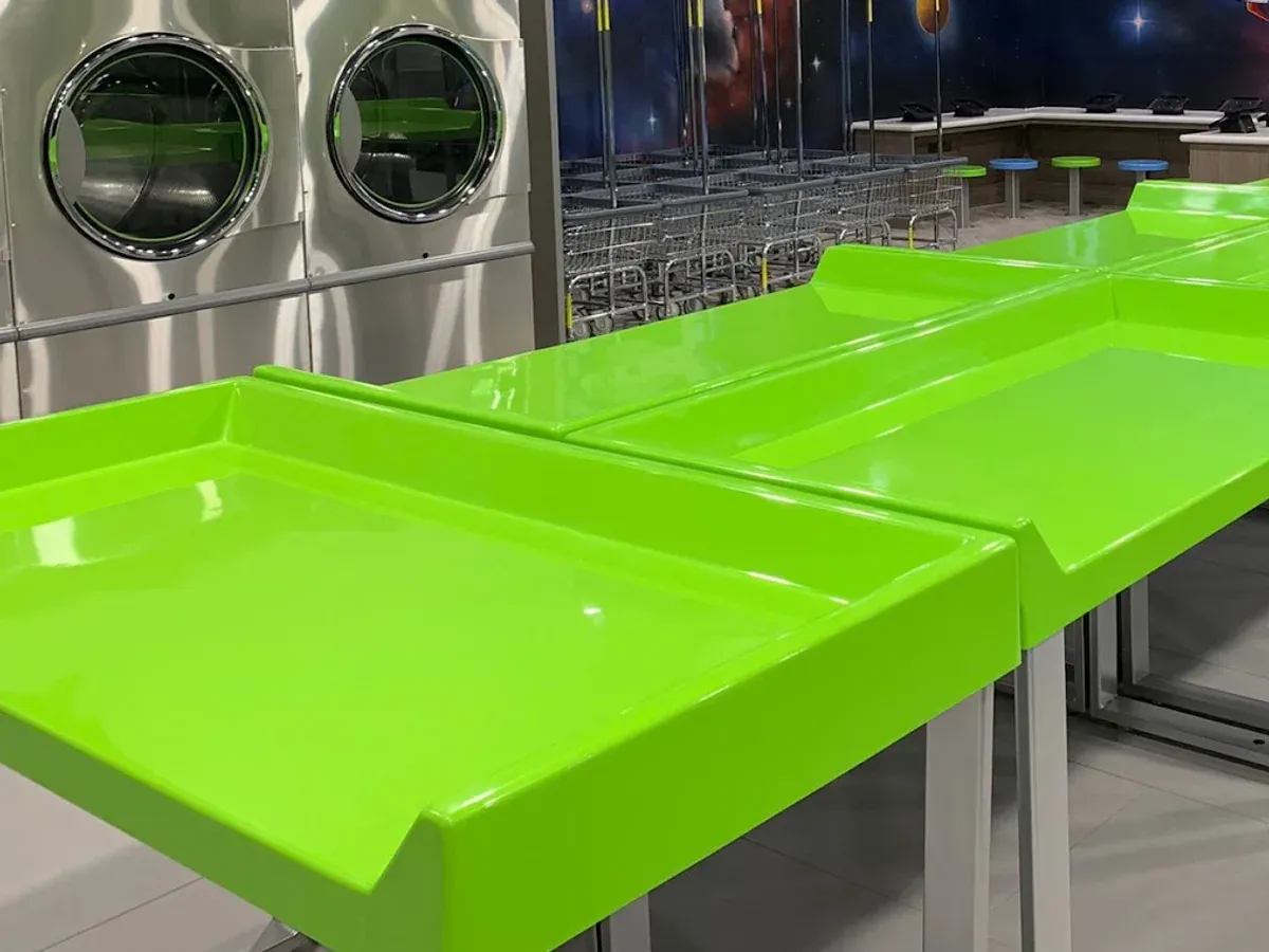 Lounge seating, laundry carts, and folding tables inside Space City Laundry.